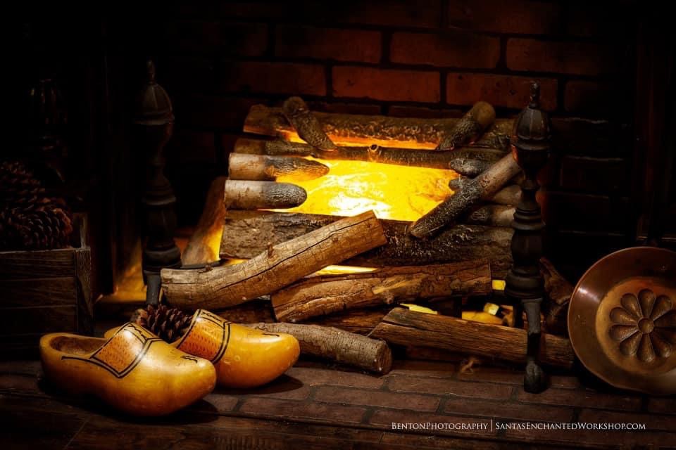 The workshop hearth glowing warm, with little wooden clogs set close to the fire