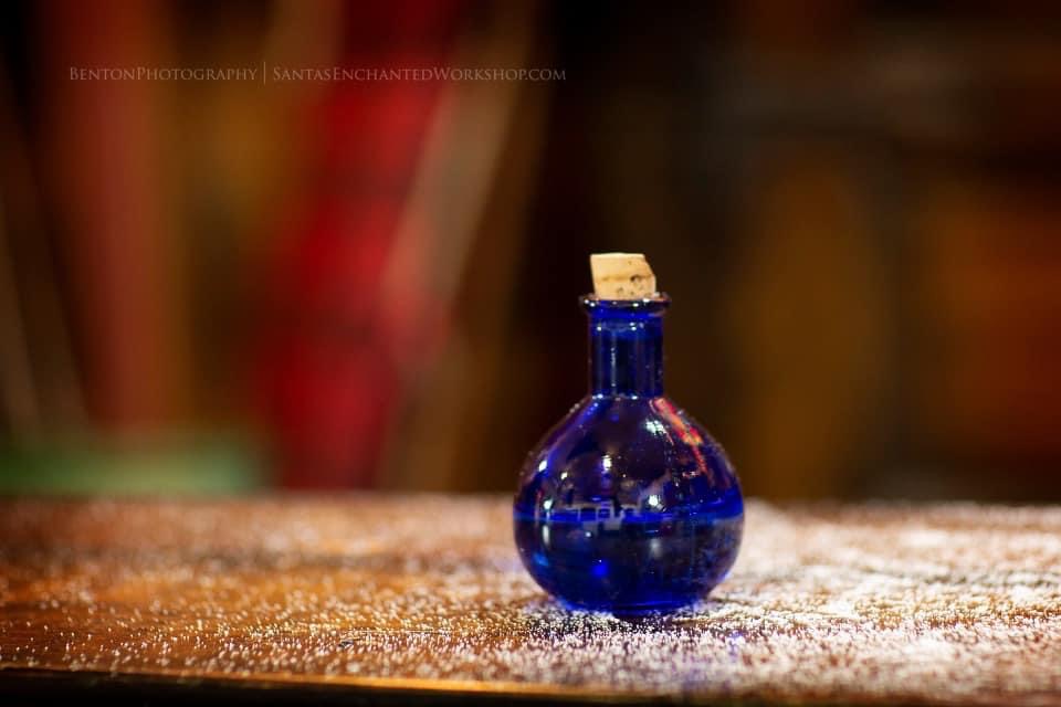 A small corked cobalt-blue bottle on a frost-dusted workbench