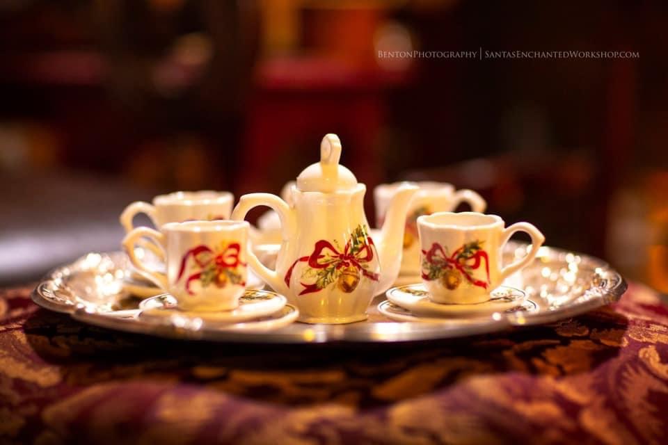 A miniature Christmas tea set laid out for small hands